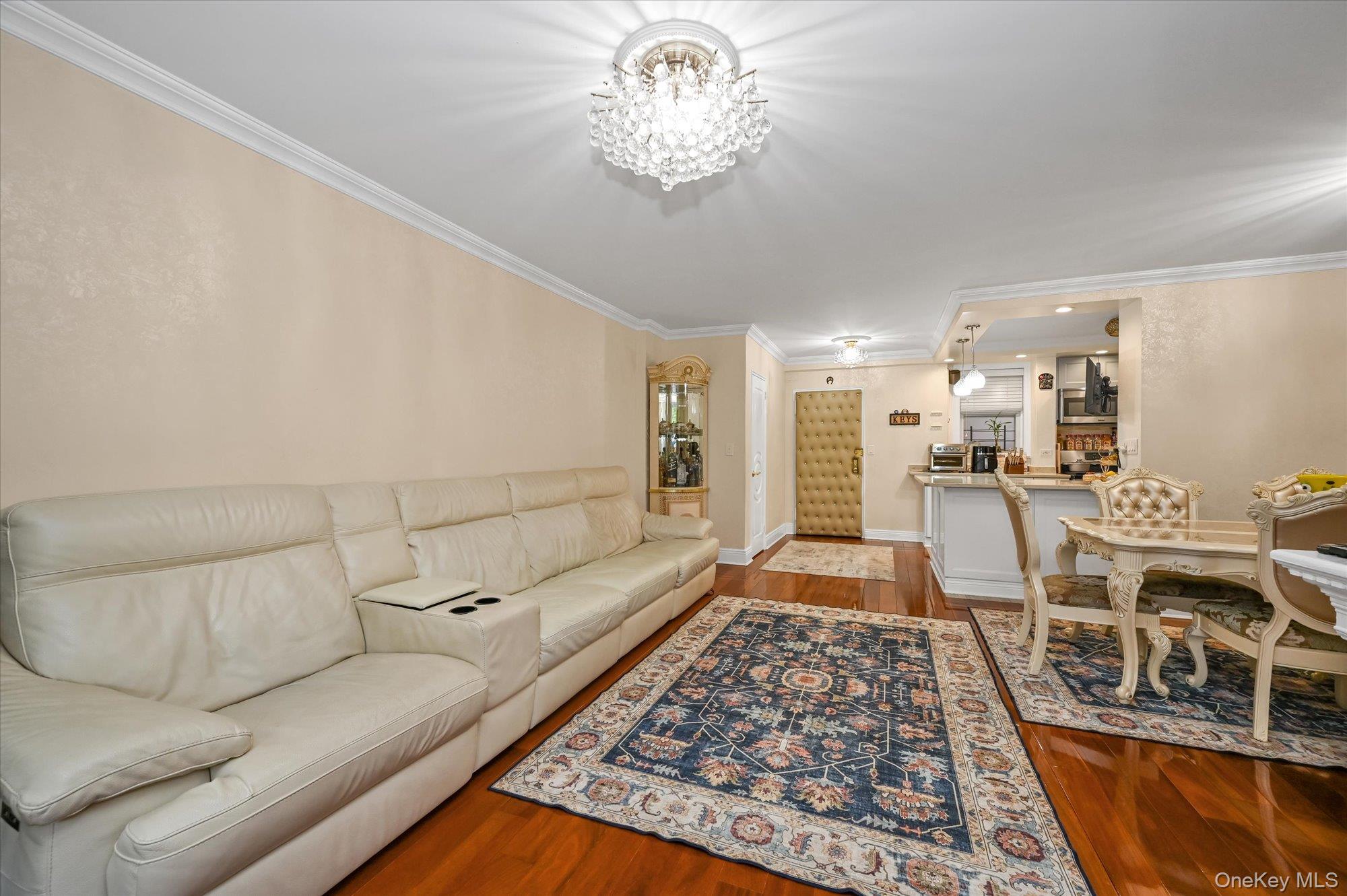 97-37 63rd Road, Unit 2J Queens, NY 11374 - Photo 2 of 19 a living room with stainless steel appliances granite countertop furniture rug and wooden floor