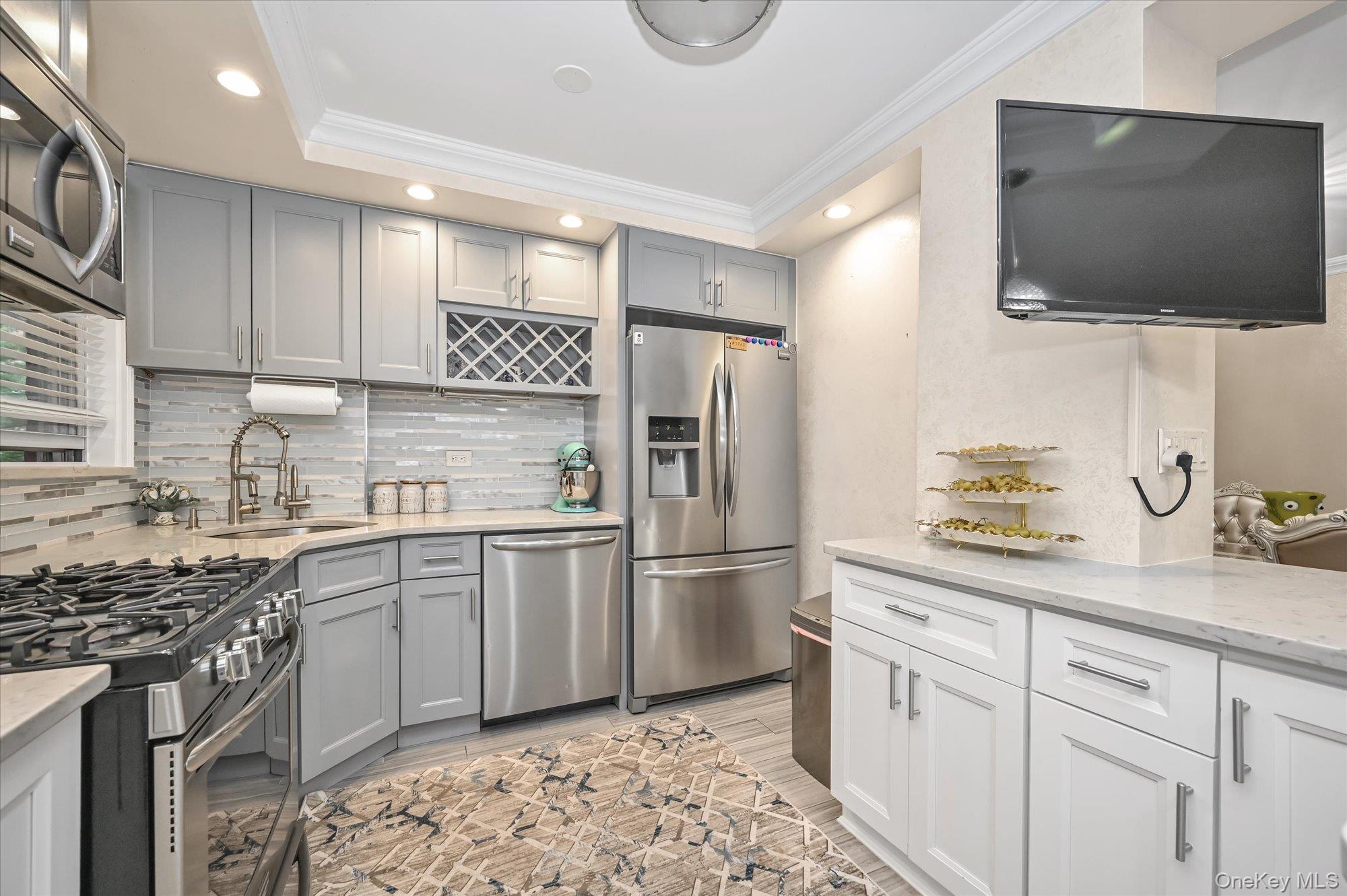 97-37 63rd Road, Unit 2J Queens, NY 11374 - Photo 6 of 19 a kitchen with a sink stainless steel appliances and cabinets