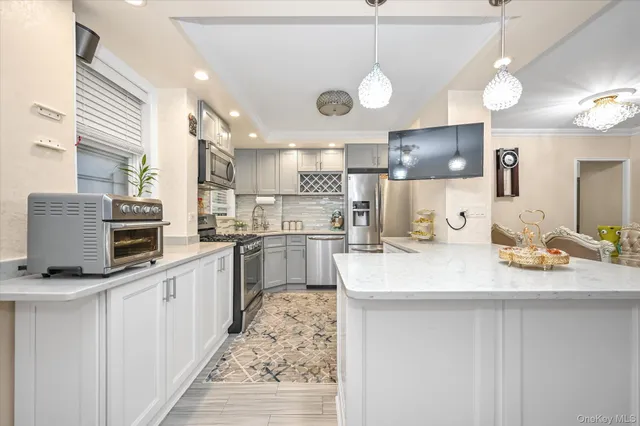 a kitchen with stainless steel appliances kitchen island granite countertop a sink a stove top oven a counter space and cabinets