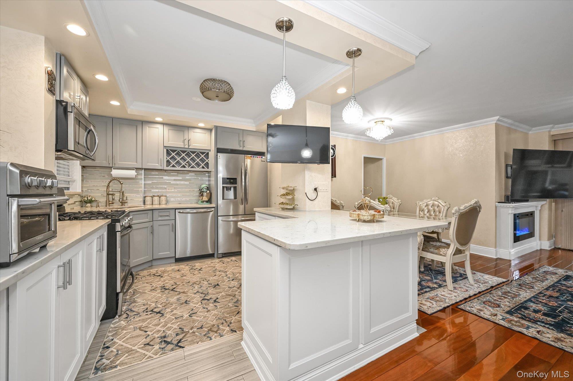 97-37 63rd Road, Unit 2J Queens, NY 11374 - Photo 9 of 19 a kitchen with a sink stainless steel appliances and cabinets