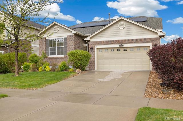 a view of a house with a yard and potted plants