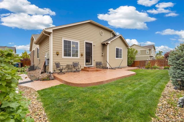 a view of a house with backyard and sitting area