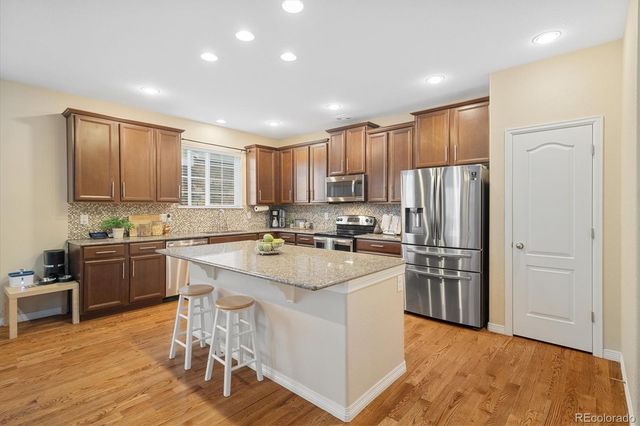 a kitchen with refrigerator cabinets and wooden floor