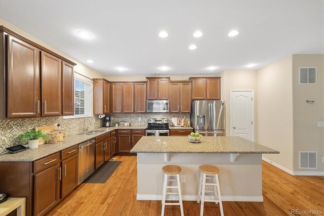 a large kitchen with kitchen island granite countertop a large center island and stainless steel appliances