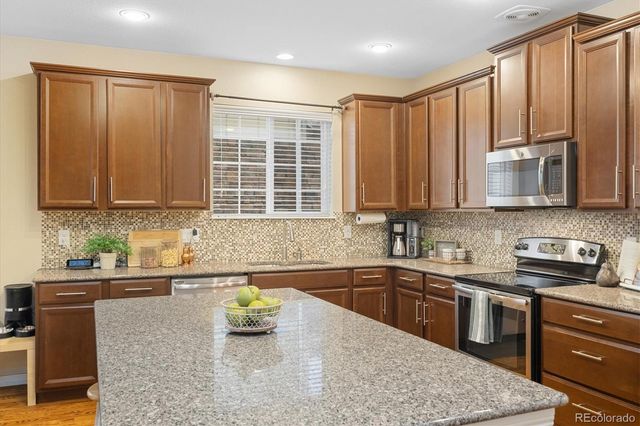 a kitchen with stainless steel appliances granite countertop a sink stove and cabinets