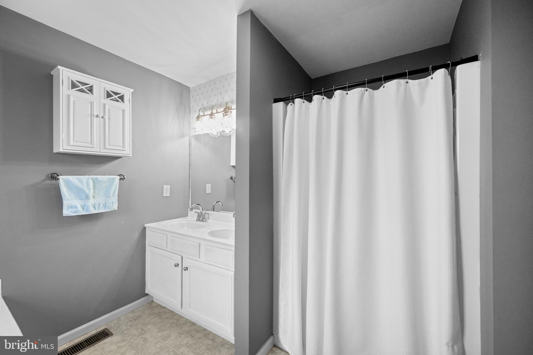 493 Buchanan Road Perkasie, PA 18944 - Photo 28 of 33 a bathroom with a sink a mirror and a shower curtain