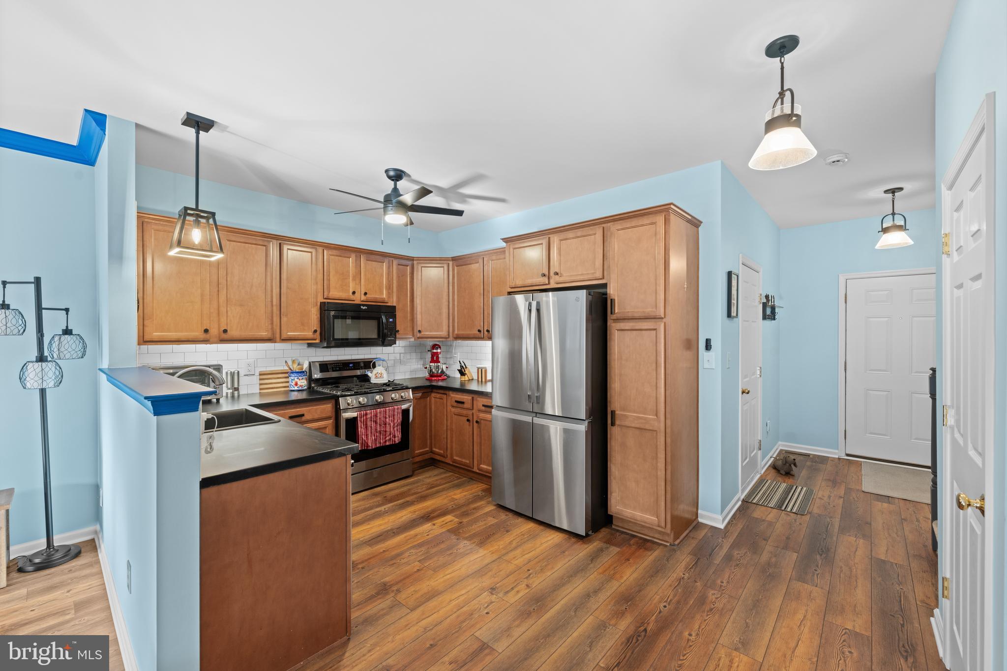 493 Buchanan Road Perkasie, PA 18944 - Photo 9 of 33 a kitchen with stainless steel appliances granite countertop a refrigerator a stove a sink dishwasher and a refrigerator with wooden floor