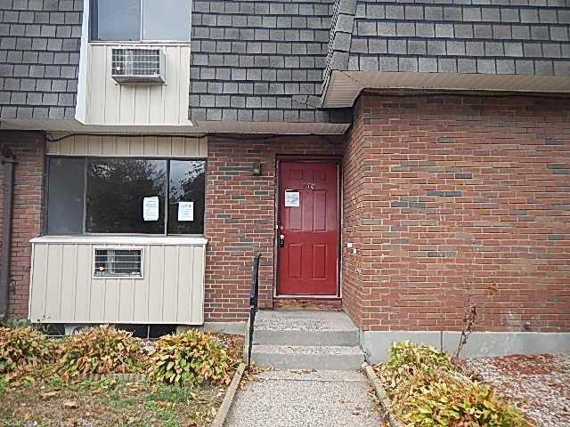 148 High Path Road, Unit 148 Windsor, CT 06095 - Photo 1 of 1 a brick building with a door and a bench
