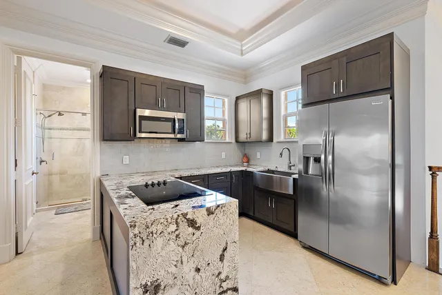 an aerial view of residential houses with outdoor space and ocean view