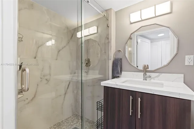 a bathroom with a sink mirror and shower