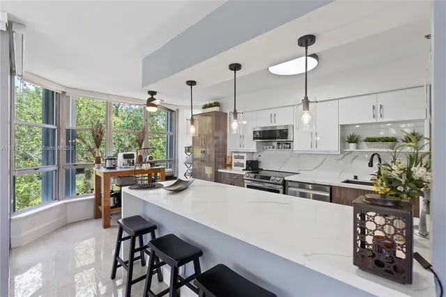 a kitchen with stainless steel appliances a table chairs and a refrigerator