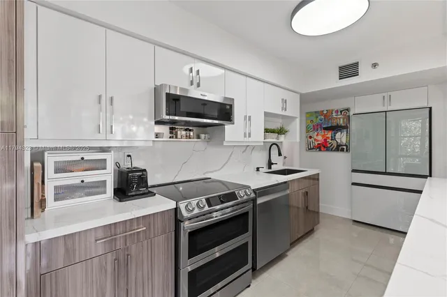 a kitchen with stainless steel appliances a sink stove top oven and cabinets