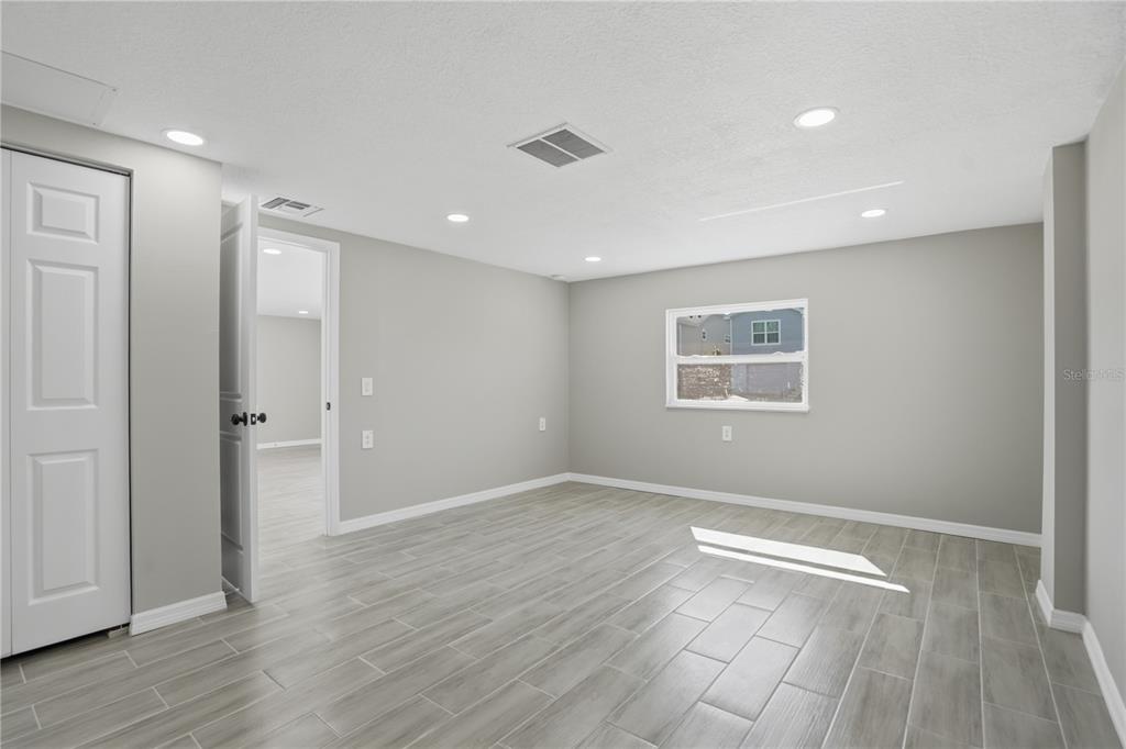 5543 Quist Drive Port Richey, FL 34668 - Photo 12 of 21 an empty room with wooden floor and windows