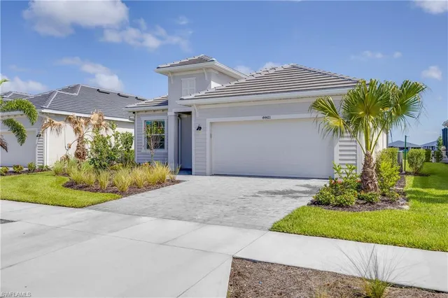a front view of a house with a garden and plants