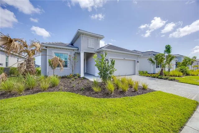 a front view of a house with a yard and a garage