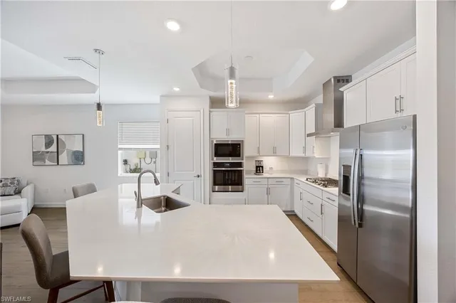 a kitchen with granite countertop a stove a sink and a white cabinets