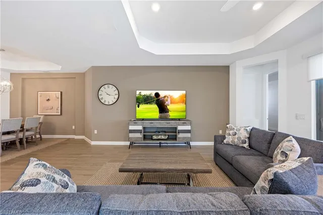 a kitchen with stainless steel appliances kitchen island granite countertop a dining table chairs refrigerator and cabinets