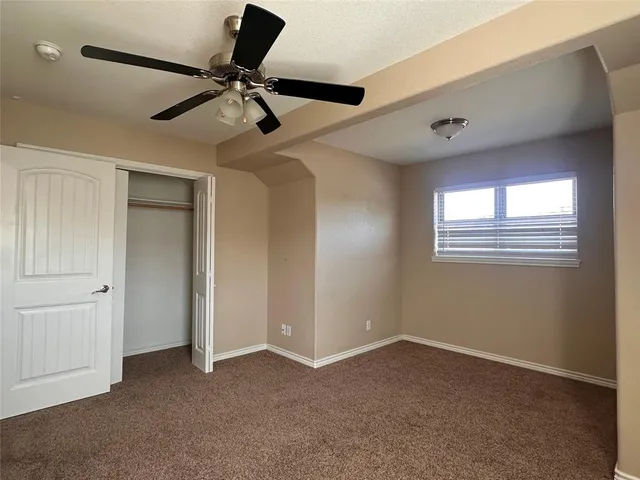 a view of a livingroom with a ceiling fan & windows