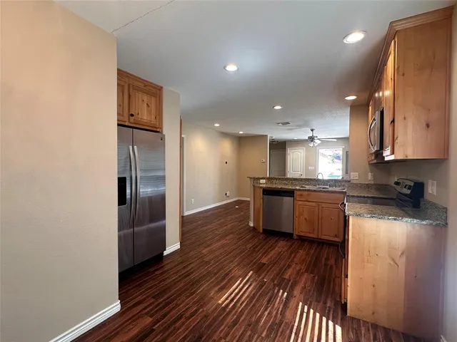 a kitchen with stainless steel appliances granite countertop a refrigerator a sink and a stove