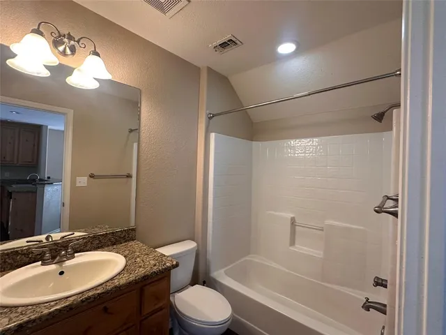 a bathroom with a granite countertop sink toilet a shower and a mirror