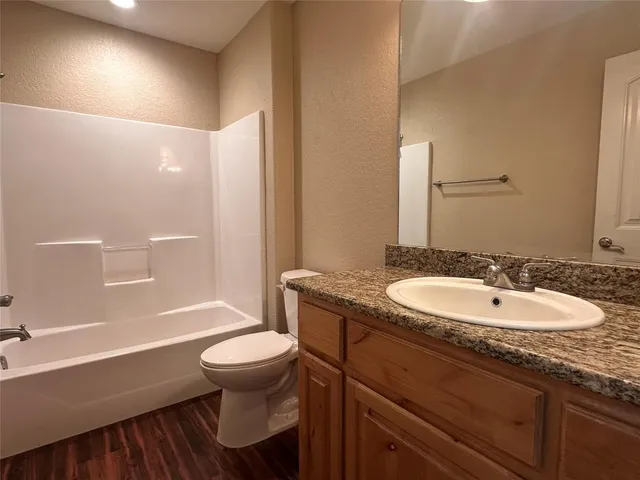 a bathroom with a granite countertop sink a toilet and a large mirror