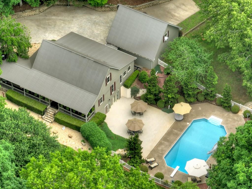 an aerial view of a house with a yard and lake