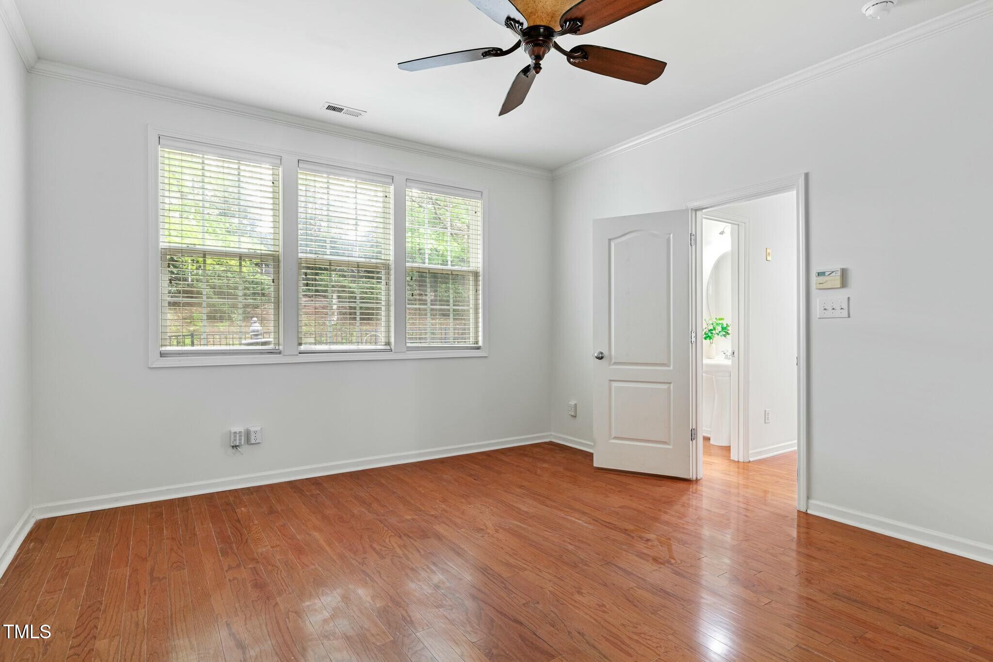 13338 Ashford Park Drive Raleigh, NC 27613 - Photo 18 of 44 a view of an empty room with a window and wooden floor