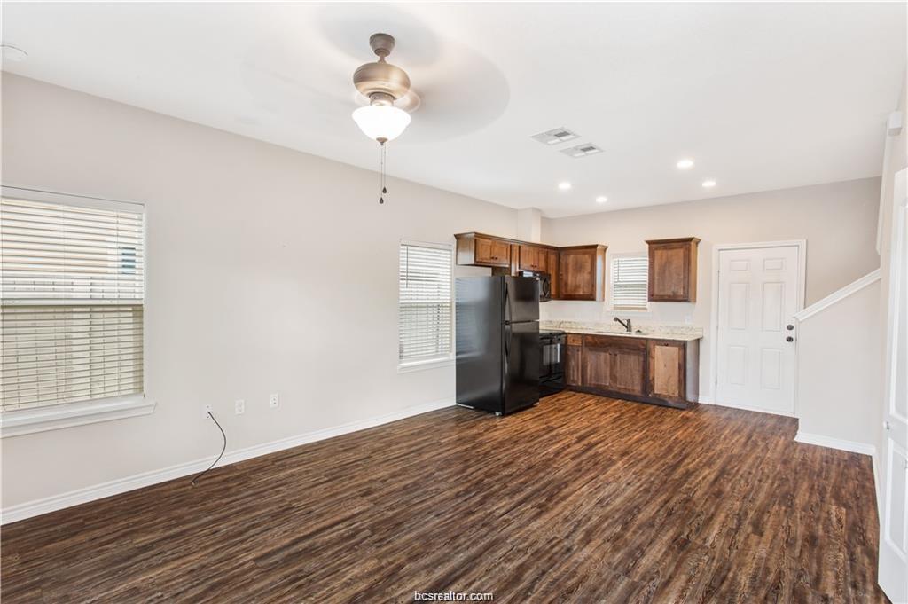 2108 Cavitt Avenue, Unit C Bryan, TX 77801 - Photo 2 of 14 a large white kitchen with a stove a sink dishwasher and a refrigerator with wooden floor