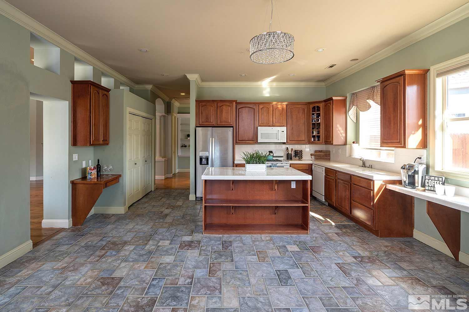9785 Rolling Rock Court Reno, NV 89521 - Photo 11 of 35 a kitchen with kitchen island a counter top space appliances and a center island