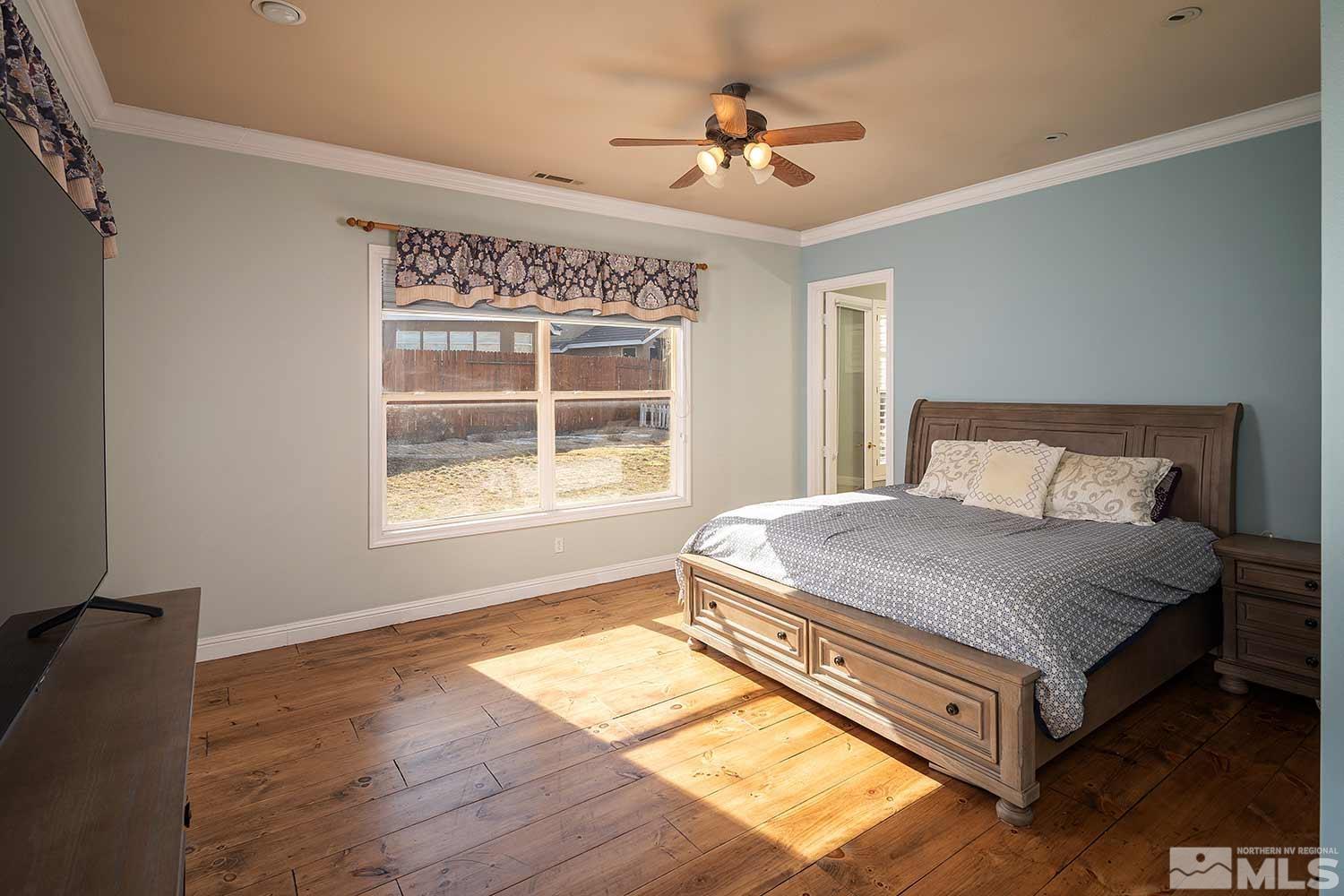 9785 Rolling Rock Court Reno, NV 89521 - Photo 16 of 35 a bed sitting in a bedroom next to a window