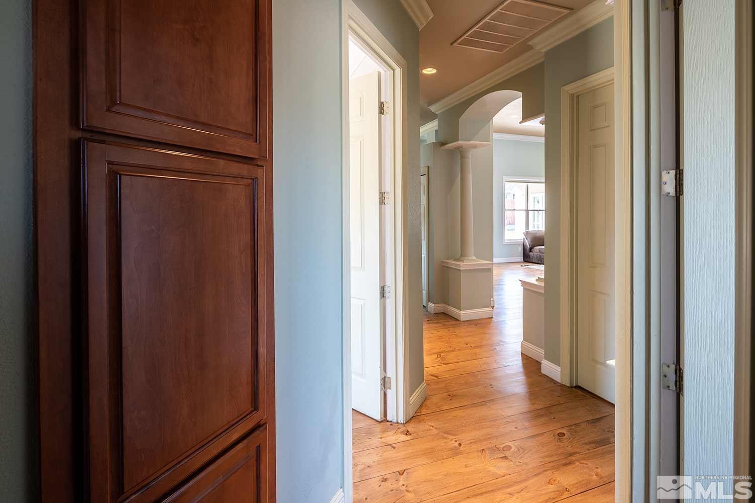 9785 Rolling Rock Court Reno, NV 89521 - Photo 8 of 35 a view of a hallway with wooden floor windows and a kitchen