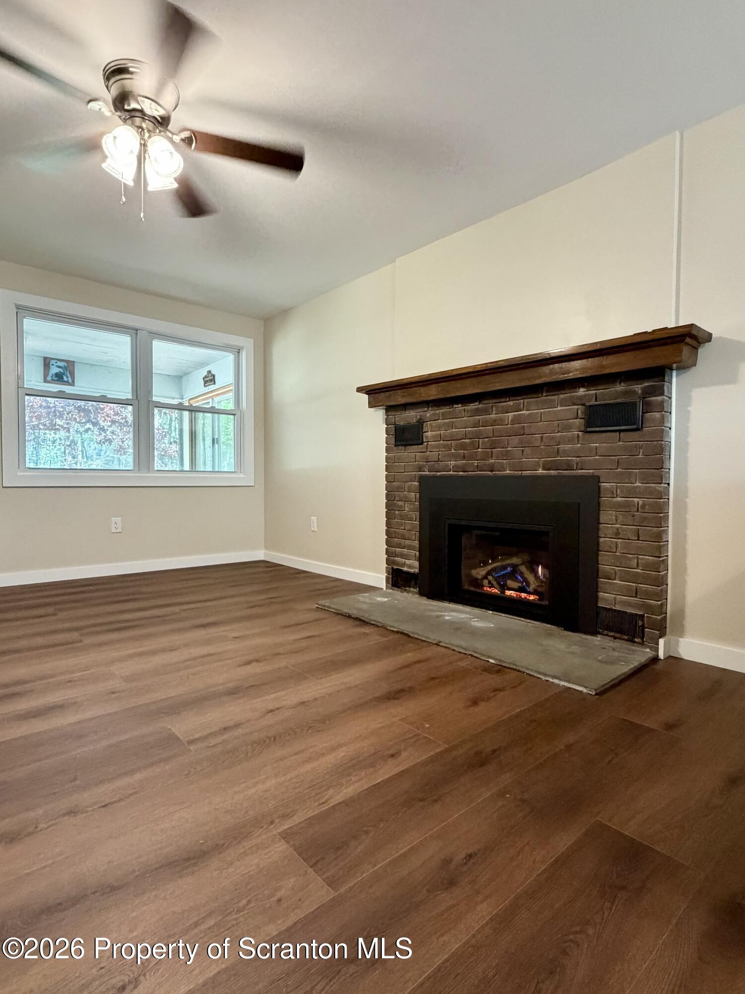 2139 Fawn Path Gouldsboro, PA 18424 - Photo 4 of 9 a view of an empty room with wooden floor fireplace and a window