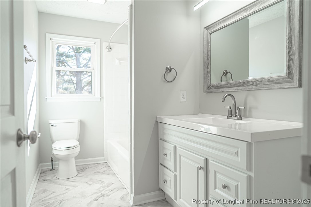 255 Foxcroft Road Whispering Pines, NC 28327 - Photo 20 of 31 a bathroom with a sink toilet and mirror