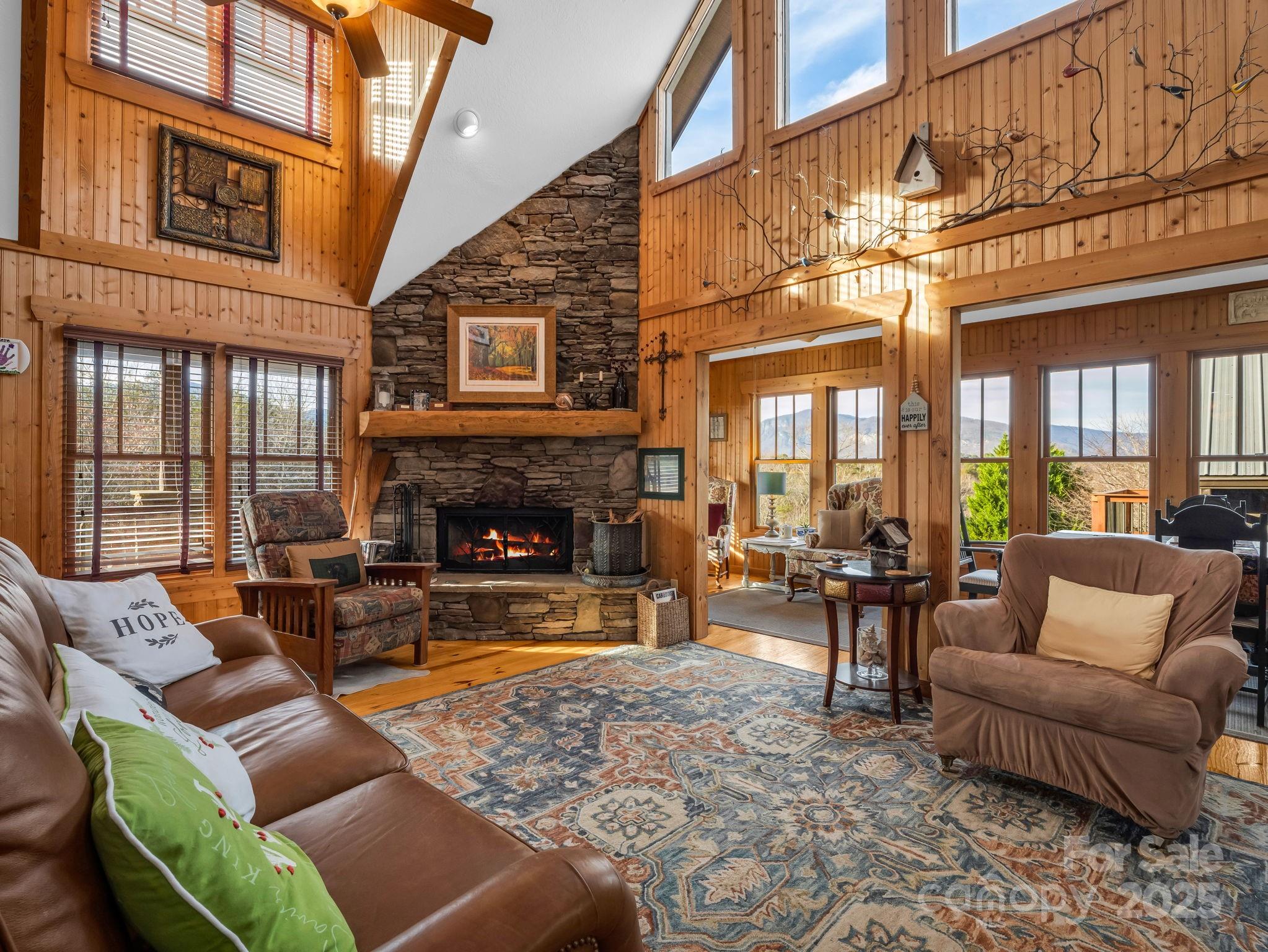 301 Peaks Drive Lake Lure, NC 28746 - Photo 13 of 48 a living room with furniture a fireplace and a ceiling fan