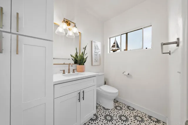 a bathroom with a sink a toilet and a mirror