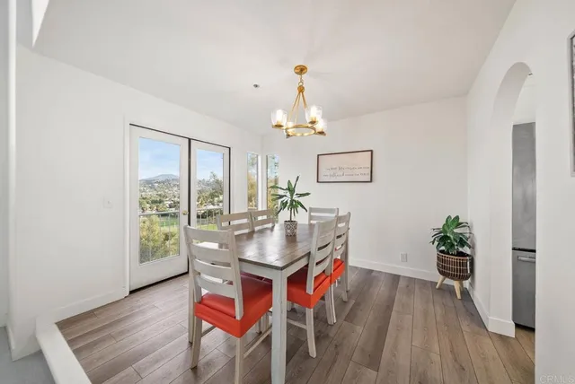 a dining room with furniture potted plants and wooden floor