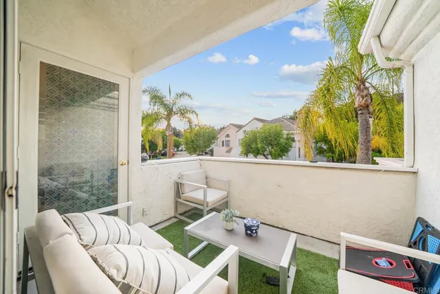 a view of a dining room with furniture a potted plant and a large window