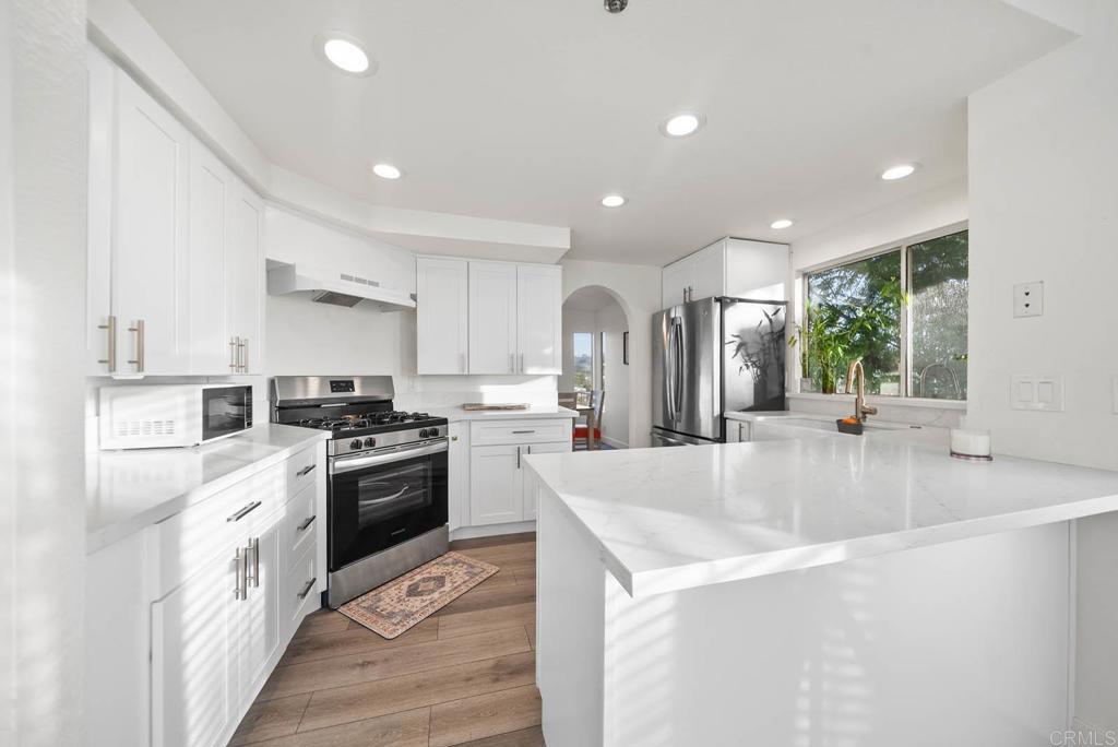 3863 Settineri Lane Spring Valley, CA 91977 - Photo 9 of 39 a large kitchen with stainless steel appliances granite countertop a lot of counter space and wooden floors