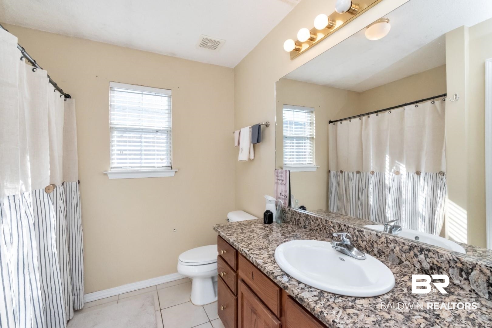 29221 Canterbury Road Daphne, AL 36526 - Photo 14 of 17 Bathroom with tile patterned flooring, vanity, toilet, and a wealth of natural light