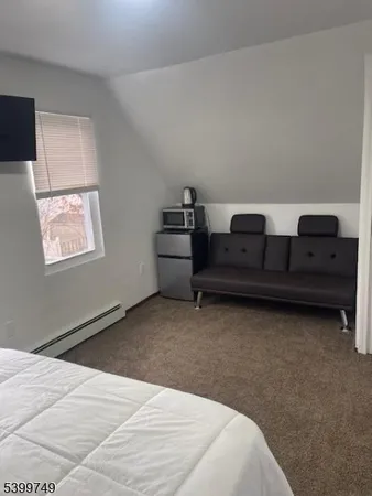 a bedroom with a bed and a lamp on dresser