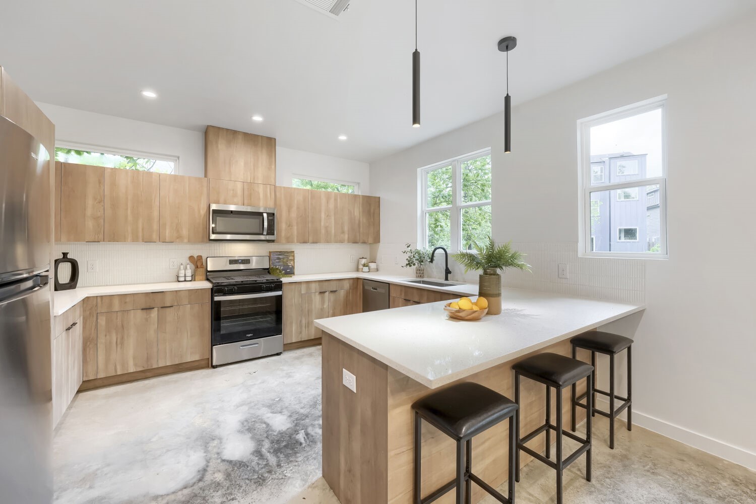 4805 Sara Drive Austin, TX 78721 - Photo 9 of 28 a kitchen with stainless steel appliances a stove a sink a center island and couches