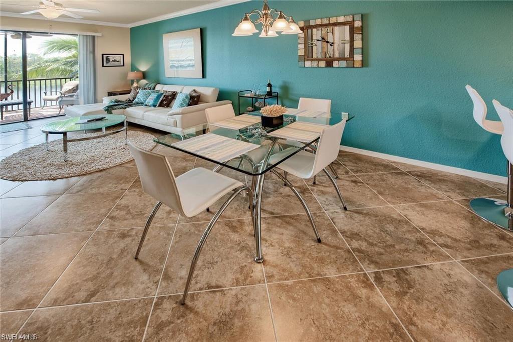 9731 Acqua Court, Unit 525 Naples, FL 34113 - Photo 7 of 35 Tiled dining area with crown molding and a chandelier