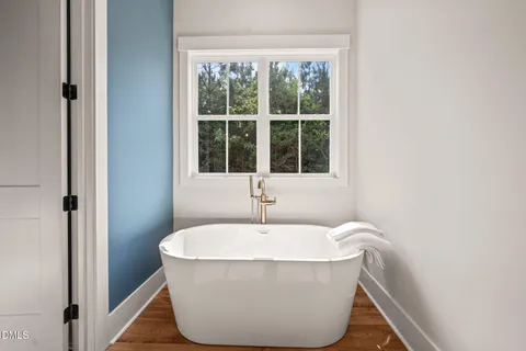a white bath tub sitting in a bathroom next to a window