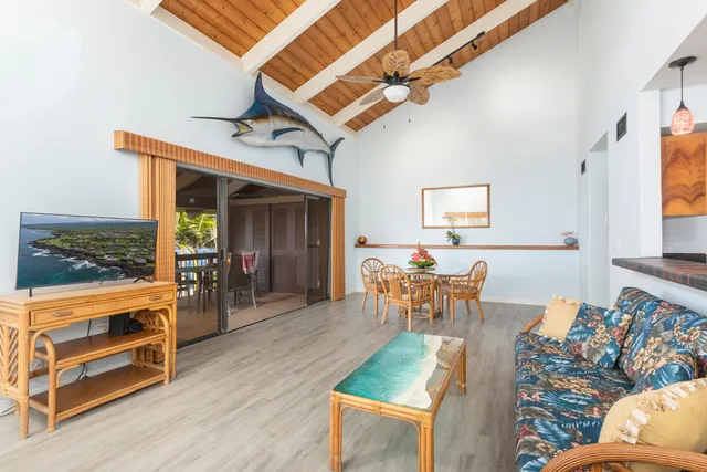 a living room with furniture a flat screen tv and a table