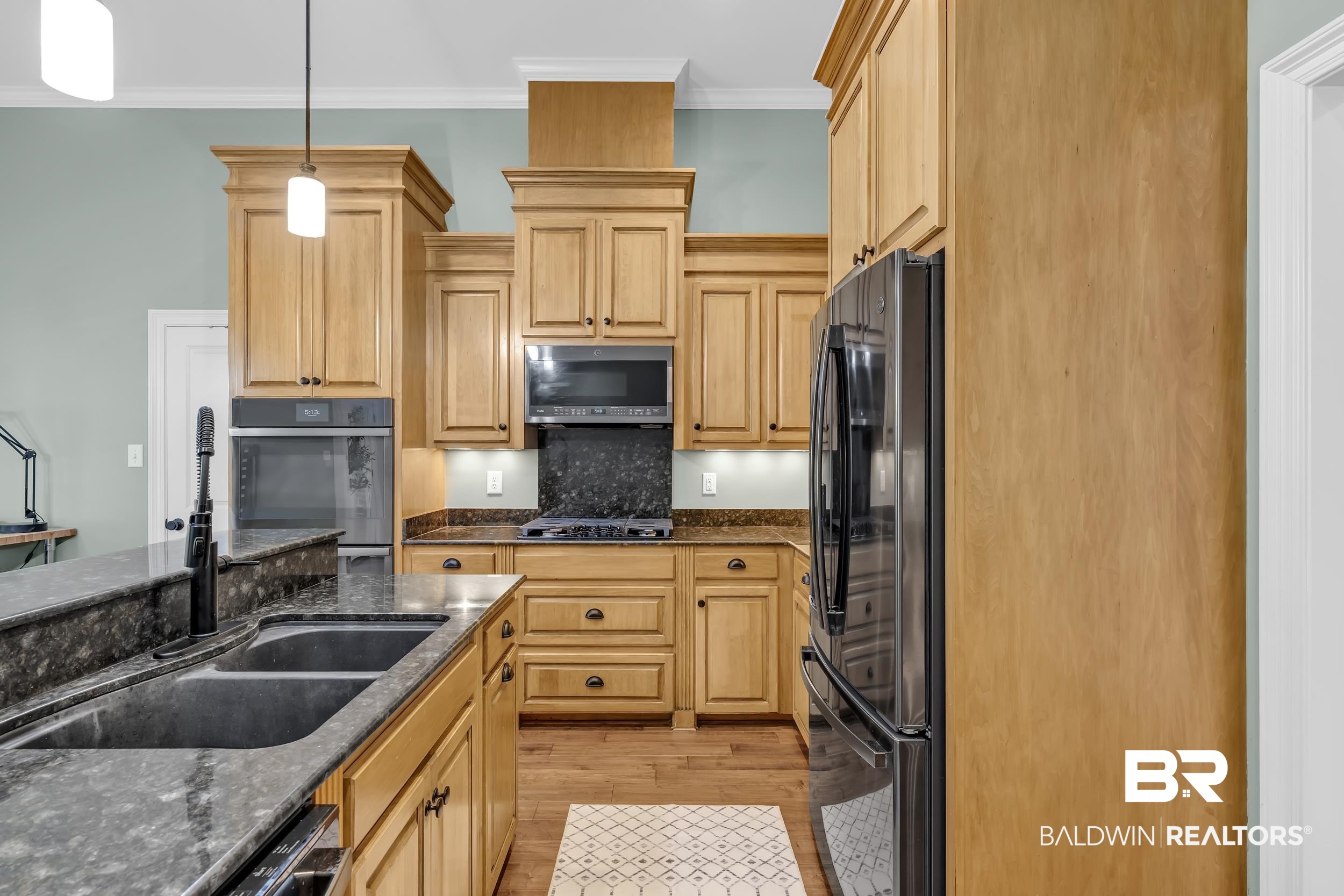 8137 Pine Run Daphne, AL 36527 - Photo 18 of 67 Kitchen featuring wood-finish cabinetry, dark granite countertops, and stainless steel appliances