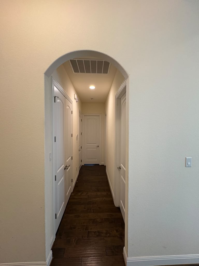 3812 Alpine Rdg Cove Leander, TX 78641 - Photo 12 of 37 An arched doorway welcomes you to a lengthy hallway with rich wood flooring.