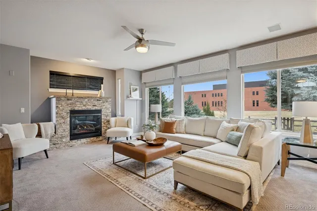 a living room with furniture a fireplace and a large window