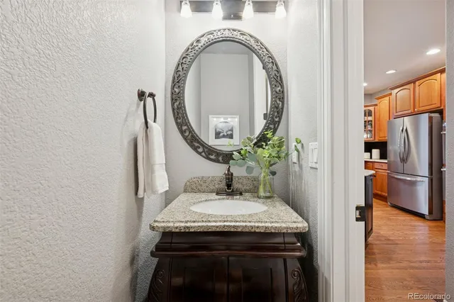 a kitchen with a sink a refrigerator and a mirror