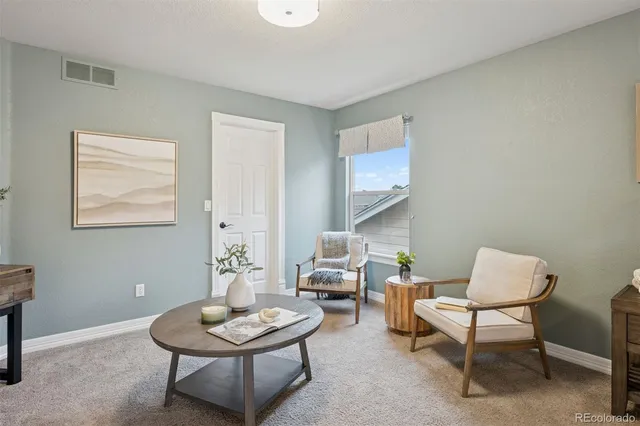 a living room with furniture a window and a potted plant