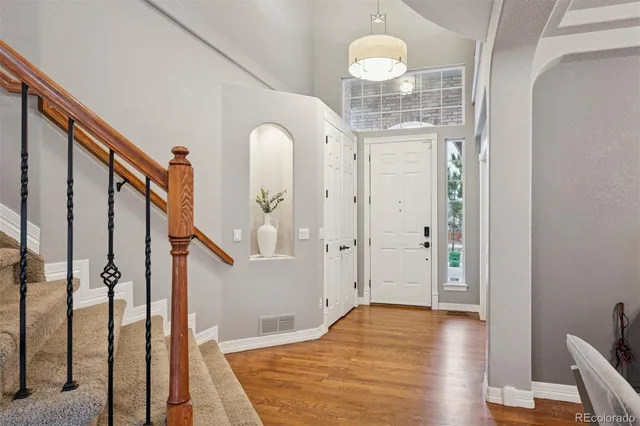 a view of a hallway with wooden floor and staircase